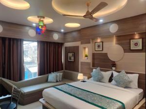 穆扎夫法尔普尔HOTEL CENTRAL SQUARE "A Couple Friendly Hotel"的带一张大床和一张沙发的卧室