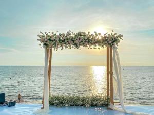 a wedding arch with flowers on the beach at Seashells Phu Quoc Hotel & Spa in Phú Quốc
