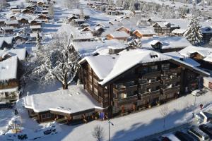 una città ricoperta di neve con un edificio di Hotel Kreuz Lenk a Lenk