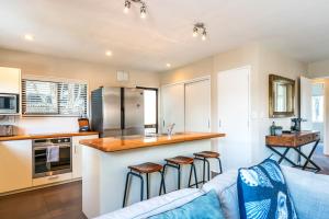 a kitchen and living room with a couch and a counter at Relax on Ridge in Oneroa