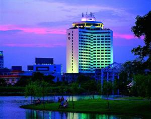 a large building with a lit up tower in a city at Zhongshan International Hotel in Zhongshan