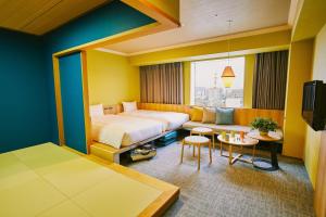 OMO7 Asahikawa by Hoshino Resorts في اساهيكاو: غرفه فندقيه بسرير واريكه