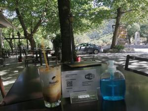 una bebida y una botella de agua sentada en una mesa en Hani Zemenou en Arachova