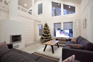 un soggiorno con albero di Natale e TV di Levi President Suksitie Chalet a Levi