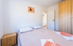 Schlafzimmer mit einem weißen Bett und einem Holzschrank in der Unterkunft S&G Leko Apartmani in Rogoznica