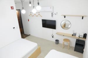 Habitación blanca con cama y espejo en Minihotel Poongdaengi en Gyeongju