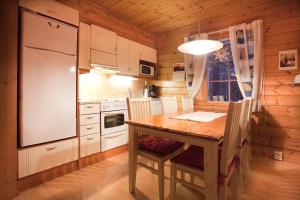 una cocina con una mesa y un refrigerador en Levi President Välirakka Chalet, en Levi