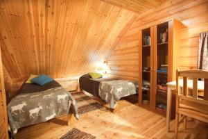 Un dormitorio con dos camas en una cabaña de madera. en Levi President Välirakka Chalet, en Levi