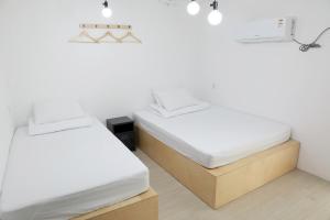 2 letti in una camera con pareti bianche di Minihotel Poongdaengi a Gyeongju