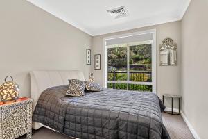 a bedroom with a large bed and a window at Private coastal getaway Corlette in Corlette