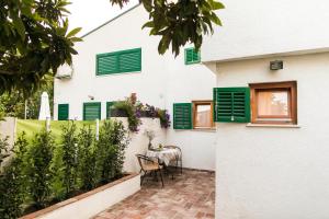 a patio of a house with green shutters at Beach House Jadrija in Šibenik