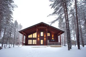 a log cabin in the woods in the snow at Levi President Suksitie Chalet in Levi