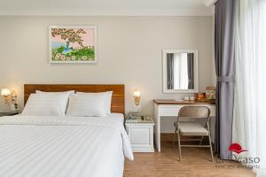 a bedroom with a white bed and a desk at El Ocaso Hotel and Apartments in Ho Chi Minh City