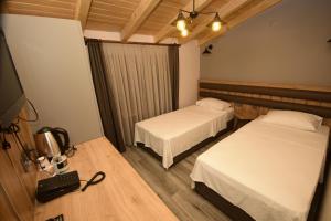 a hotel room with two beds and a television at KORU BUTİK OTEL in Artvin