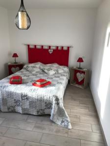 a bedroom with a bed with a red headboard at GITE DE FRANCE "A l'essentiel" in Sidiailles
