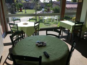 een eetkamer met een tafel en stoelen en een raam bij Le Logis des Cordeliers in Condom