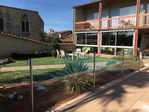 a house with a courtyard with a table and chairs at Le Logis des Cordeliers in Condom