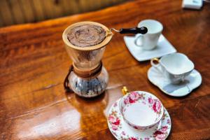 Lijiang Sunshine Nali Inn في ليجيانغ: طاولة خشبية مع مشروب وكوب من القهوة