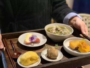 een dienblad met borden eten op een tafel bij Lijiang Sunshine Nali Inn in Lijiang