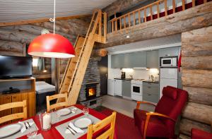 une cuisine et une salle à manger avec une table et des chaises rouges dans l'établissement Holiday Club Ylläs Apartments and Cottages, à Äkäslompolo