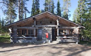 a log cabin in the woods with a red box at Holiday Club Ylläs Apartments and Cottages in Äkäslompolo