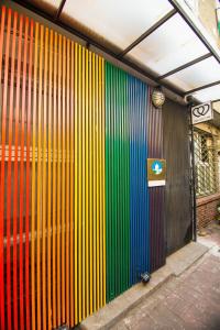 una pared con rayas coloridas en el lateral de un edificio en One Heart Inn, en Tainan