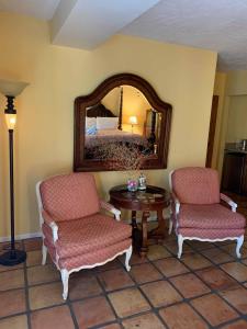 a room with two chairs and a table and a mirror at La Maison Hotel - Adults Only in Palm Springs