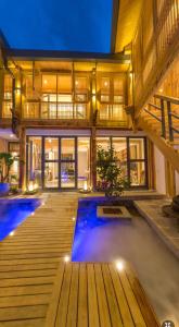 Lijiang Sunshine Nali Inn في ليجيانغ: منزل به مسبح وسطح