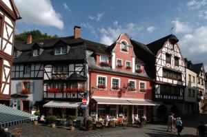 ein großes Gebäude mit Leuten, die draußen sitzen in der Unterkunft Gast-und Weinhaus Burkard in Bernkastel-Kues