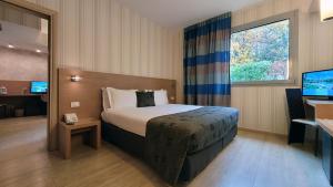 a hotel room with a bed and a television at Relais Bellaria Hotel & Congressi in Bologna