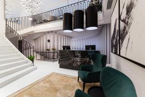 a lobby with a staircase and green chairs at The Embassy Valletta Hotel in Valletta