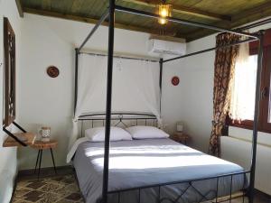 1 dormitorio con 1 cama con dosel de metal en Rustic House, en Émbonas
