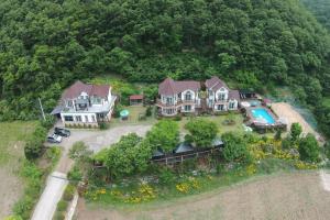 una vista aérea de una casa grande con piscina en Forest of Color Pension en Hongcheon