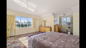 a bedroom with a large bed and two windows at Amy's Forest City Villa in Rotorua