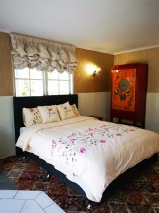 a bedroom with a large bed with flowers on it at Amy's Forest City Villa in Rotorua