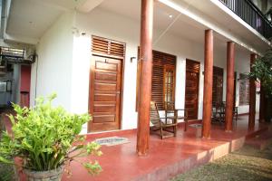 a building with wooden doors and chairs and plants at Sea Zone Resort in Mirissa