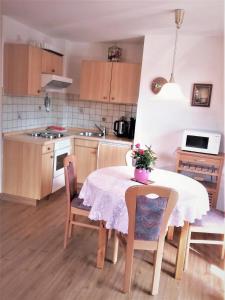 a kitchen with a table and chairs and a kitchen with a table and a table at Ferienhaus im Park in Hinterzarten