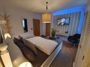 a bedroom with a large bed with a tv on it at Reinhardshäusle Pension & Wellness in Reinhardshausen