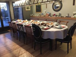 een lange tafel met stoelen en eten erop bij Le Clos du miroir in Courset