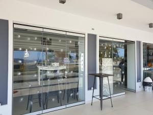 a glass wall with a table in a building at ANGELO Cafe Hotel in Tolo