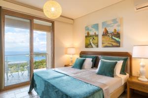 une chambre avec un lit et une grande fenêtre dans l'établissement Villa Pietra Gialla by Rodostamo Collection, à Kassiopi