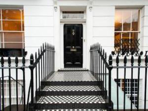 a black door on a white house with stairs at Central London House Zone 1 in London