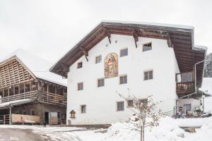 a large white building with a wooden roof at Ladinser Hof Reiterstube in Castelrotto