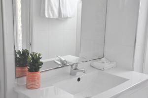 ein weißes Badezimmer mit einem Waschbecken und einem Spiegel in der Unterkunft Palm Waters Holiday Villas in Townsville