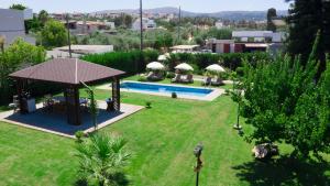 una vista aérea de un jardín con piscina y sombrillas en Euphoria Home, en Pigi