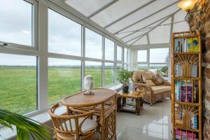 a conservatory with windows and a table with a bird on it at Cottage - Sleeps 5 - Hot Tub - Garden - Parking in Lancaster