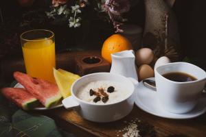 a breakfast table with a bowl of cereal and a cup of coffee and fruit at Alicia Apartelle in Cebu City