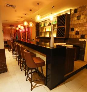 a bar in a restaurant with a row of chairs at TDI Club Retreat Kundli in Sonīpat