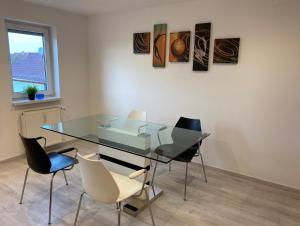 a dining room with a glass table and chairs at Ferienwohnung Hendrich Roßleben in Roßleben