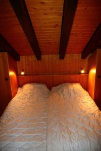 een groot wit bed in een kamer met houten plafonds bij Greppons O 040 - MOUNTAIN apartment 8 pers in Veysonnaz